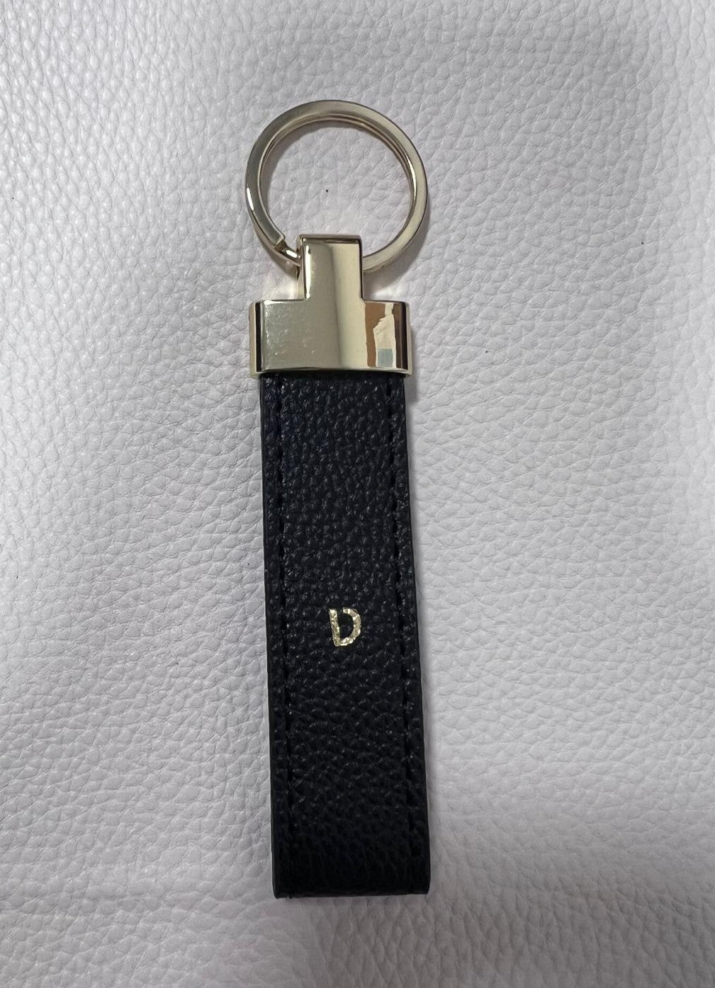 OUTLET - מחזיק מפתחות בגוון שחור-זהב עם הטבעת זהב ט